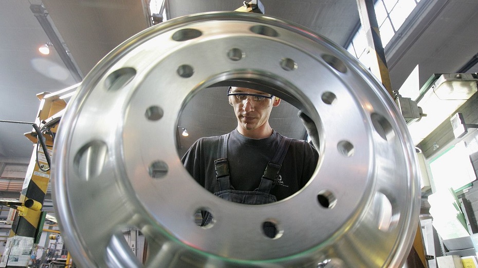 A man standing behind an Alcoa® wheel testing it