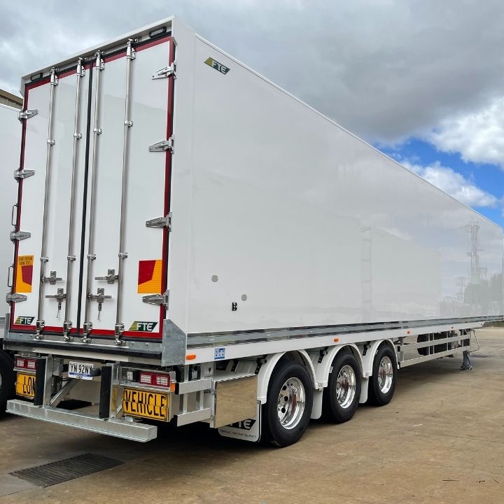 Backend of a white PBS 26 pallet FTE trailer on Alcoa wheels