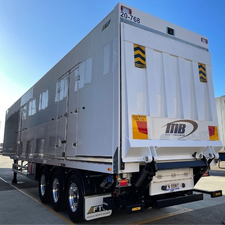 Backend of a white FTE temperature-controlled unit on Alcoa wheels with a black logo above the rego plate saying MB