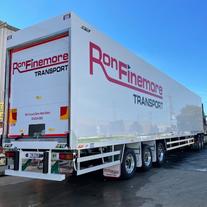 Backend of a white 26 pallet FTE trailer on Alcoa wheels with red signage saying Ron Finemore Transport